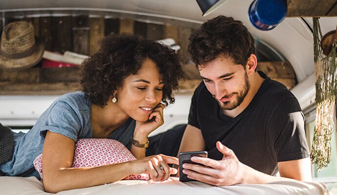 man enjoying meal  looking at cell phone launching Norton 360 Standard.